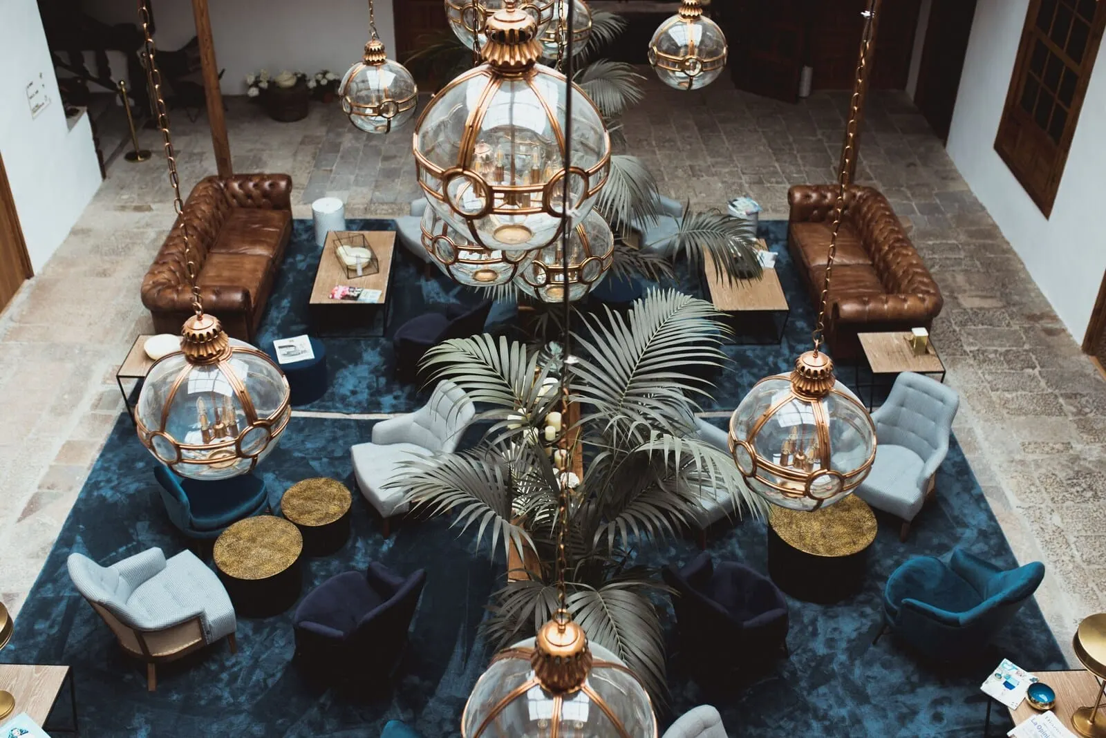 La Laguna Gran Hotel: A spacious lounge area with leather sofas, round tables, and hanging spherical lamps