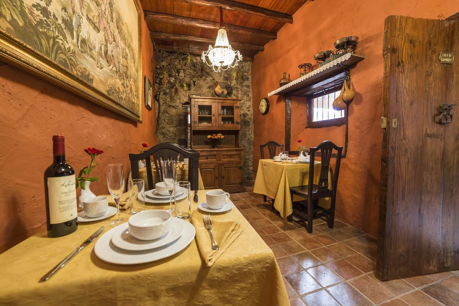 Hotel Emblemático San Marcos: A dining area with a table set for two, a wine bottle, and a painting on the wall