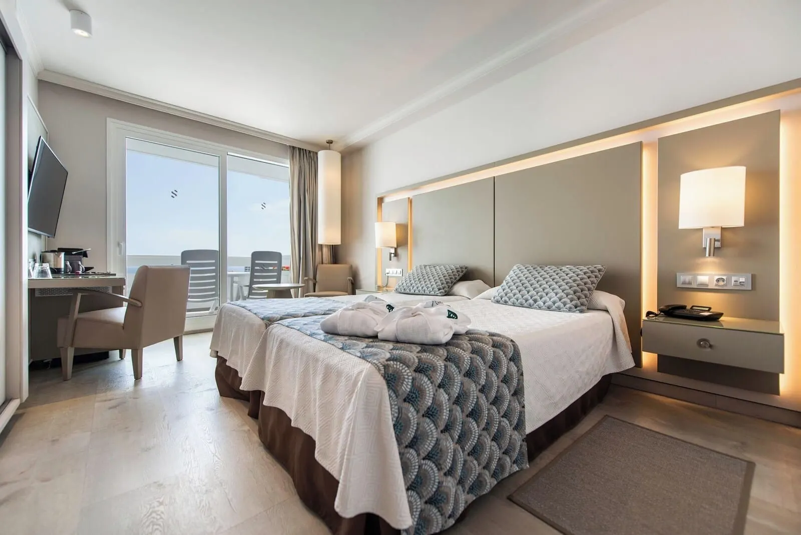 Spring Hotel Vulcano: A hotel room with a bed, a desk, a chair, a TV, and a balcony with a view