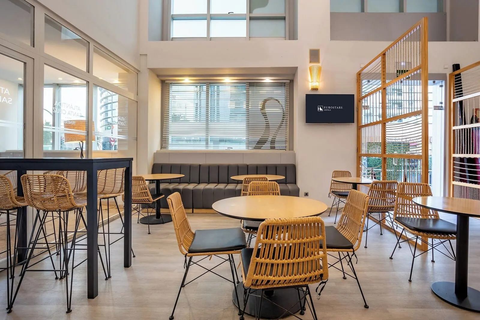 Eurostars Atlántida: A modern lounge area with round tables and wicker chairs, a sofa