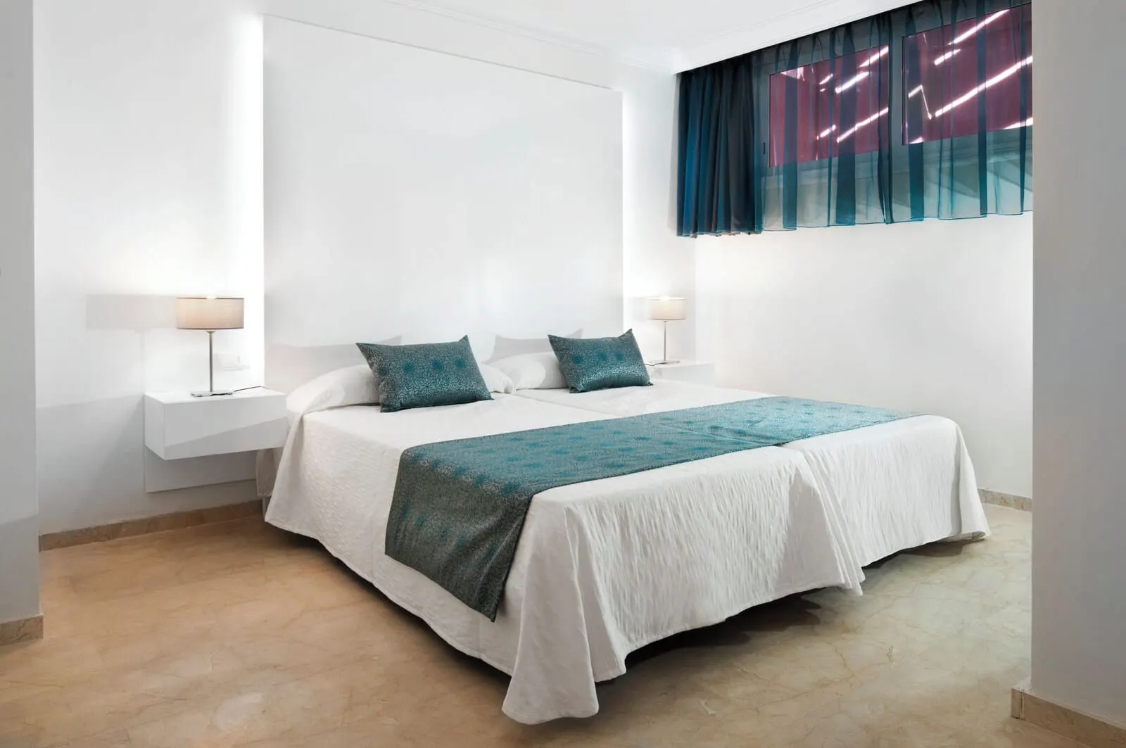 KN Aparthotel Panorámica: A neatly arranged bedroom with a large bed, two bedside tables with lamps