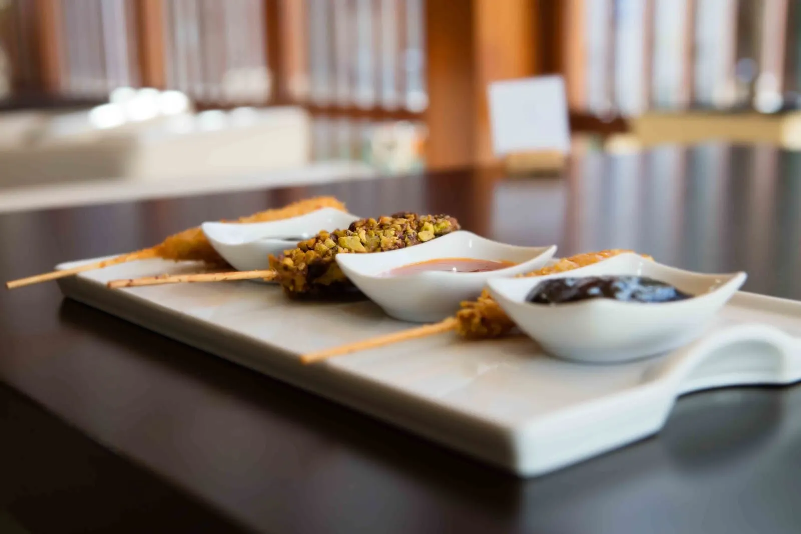Hotel Escuela Santa Cruz: A tray of skewered food items with dipping sauces on a table