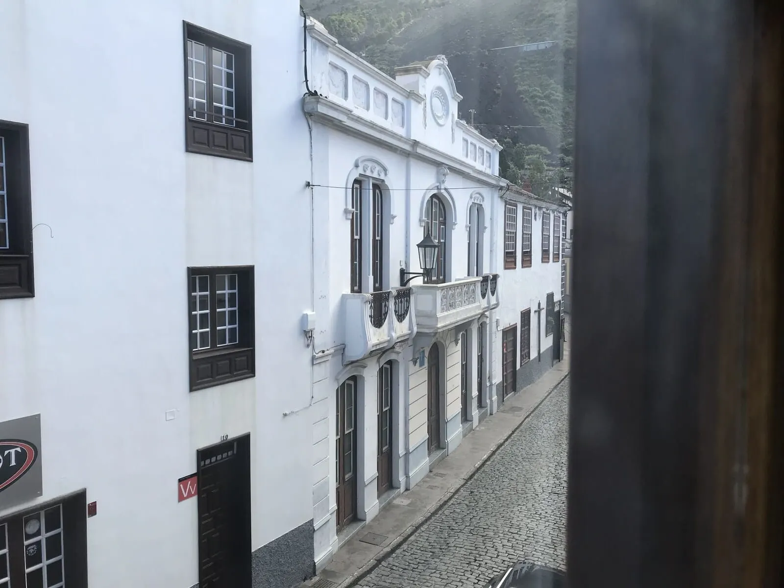 Garahotel: A street view of a building with a white facade, multiple windows