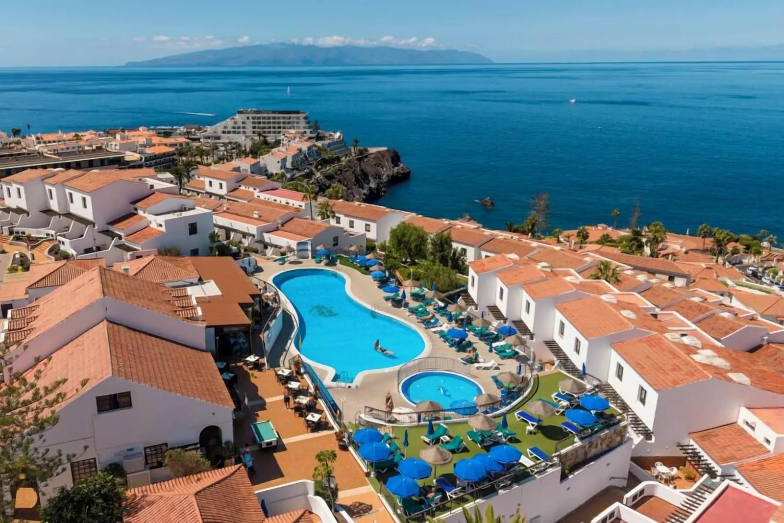 Ona Las Rosas: A resort with a large swimming pool, multiple guest rooms, and a view of the sea