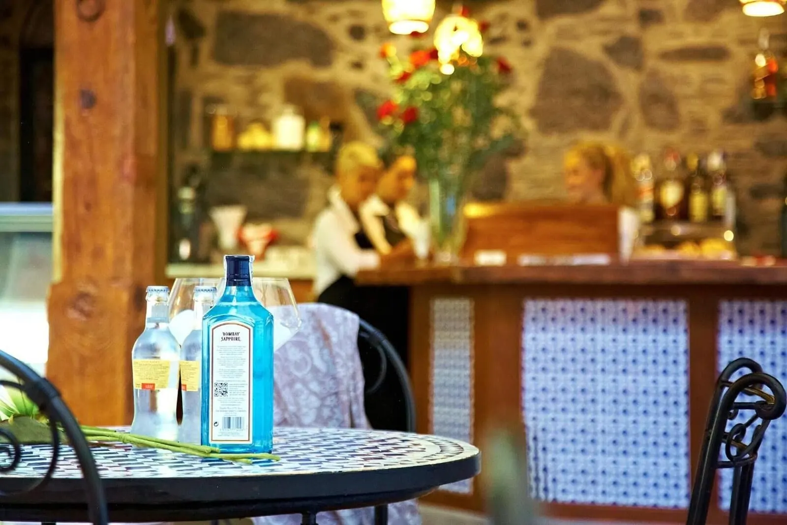 Hotel Emblemático San Agustín: A bar area with a round table, bottles of Bombay Sapphire Gin