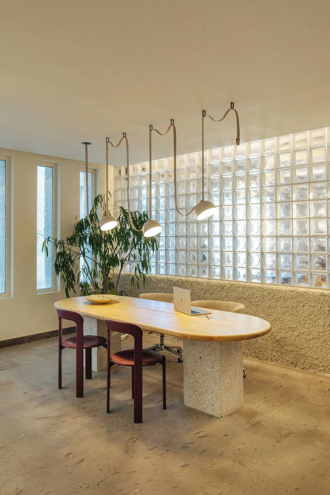 Hotel Taro Santa Cruz: A modern dining area with a round table, two chairs, a laptop, and a potted plant