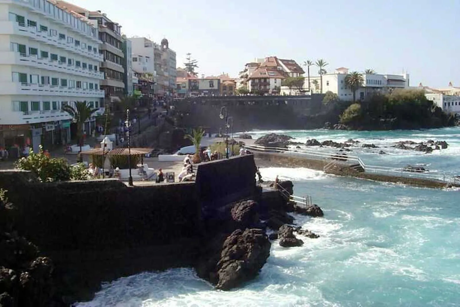 Marquesa Hotel: A coastal hotel with multiple floors, a rocky shoreline, and a view of the sea