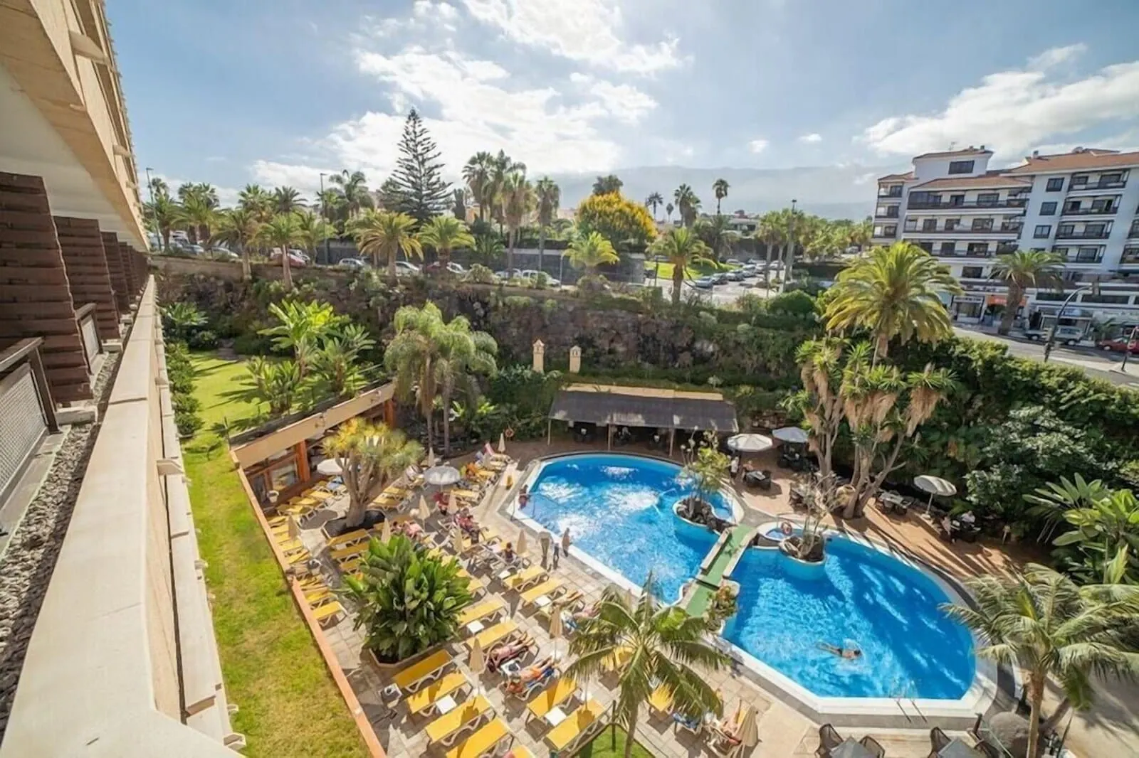 FERGUS Puerto de la Cruz: A rooftop pool area with multiple swimming pools, lounge chairs, and palm trees