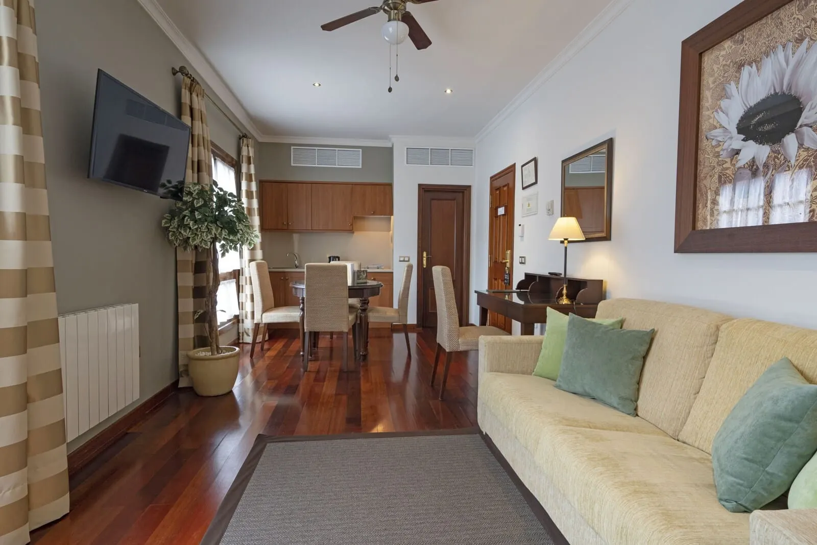 Laguna Nivaria Hotel & Spa: A living room with a sofa, a TV, and a dining area with chairs and a table