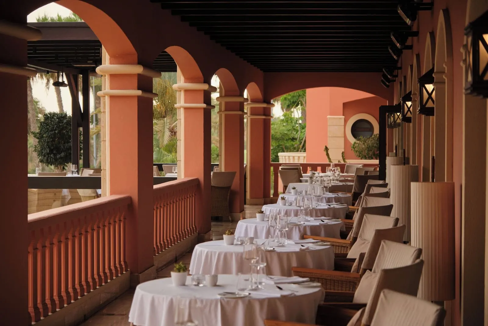 1881 Tenerife Madrigueras Golf Hotel: A restaurant with round tables and chairs, covered by a roof with arches