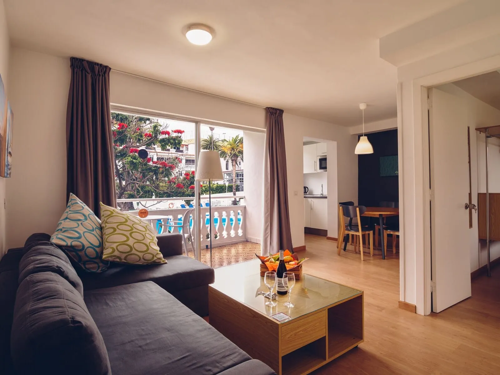 Route Active Hotel: A modern living room with a sofa, coffee table, and a balcony with curtains