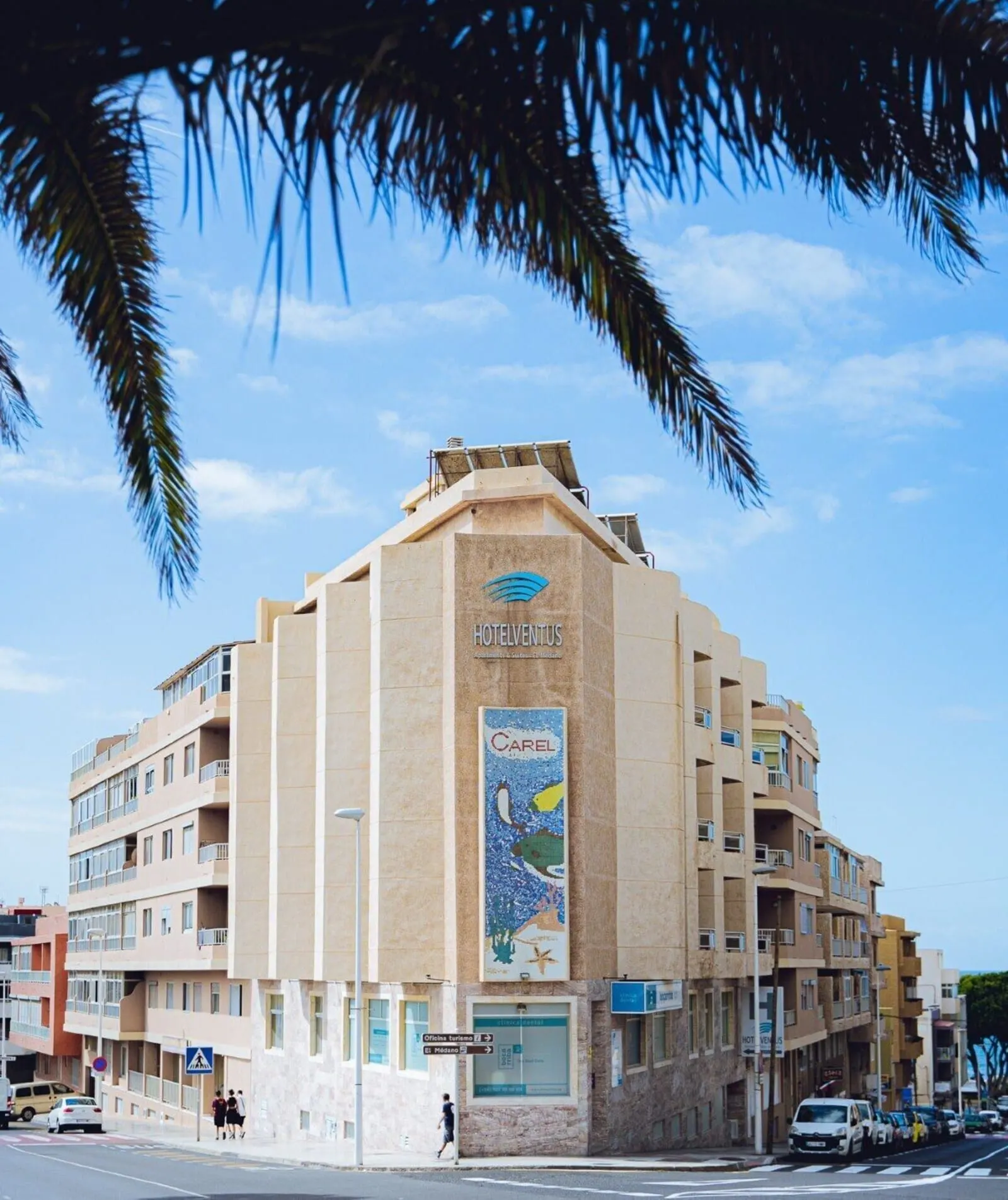Hotel Ventus: A multi-story hotel with a prominent vertical banner advertising a nearby beach