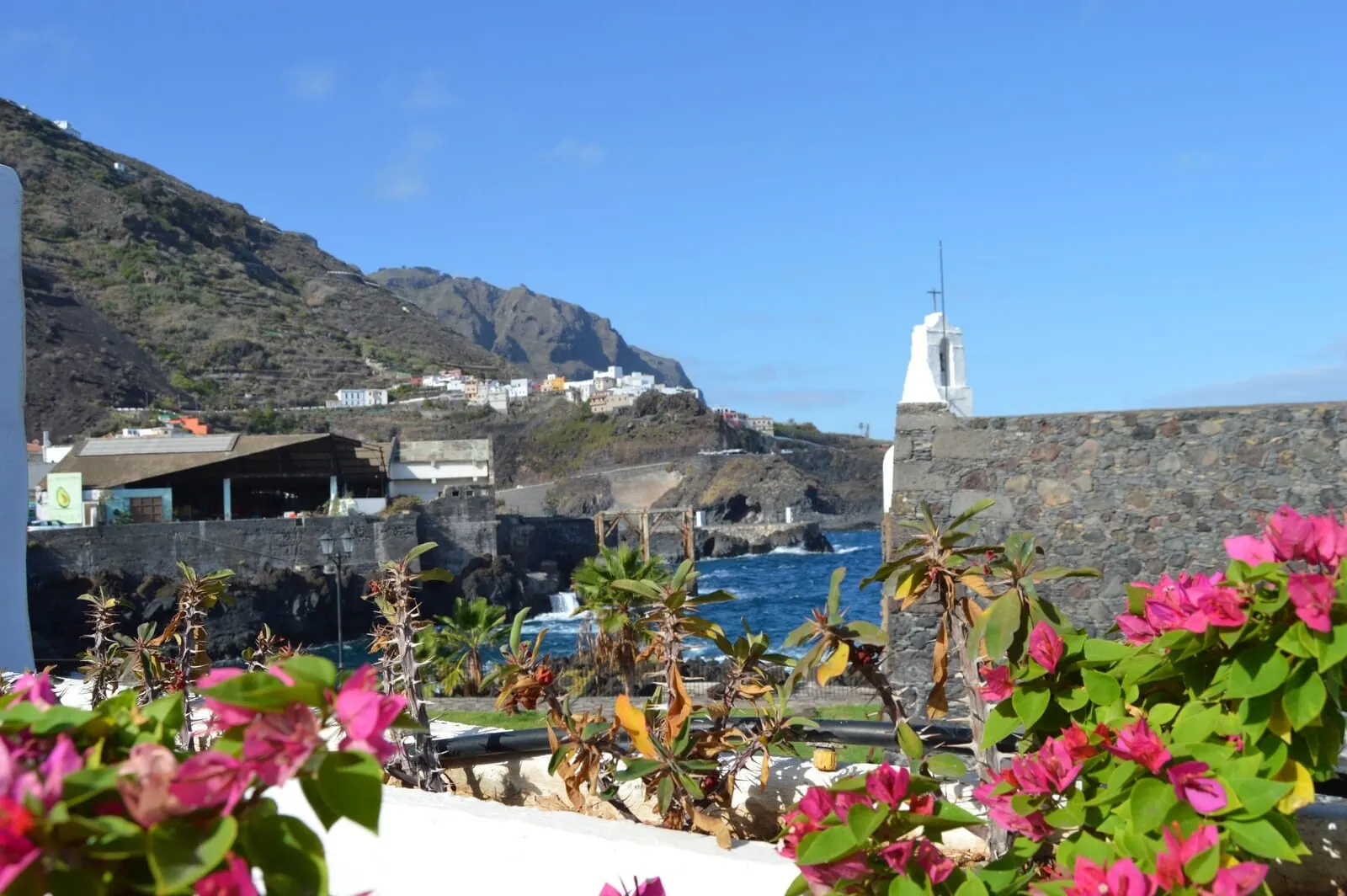 Garahotel: A coastal town with a prominent white church on a hill, rocky terrain