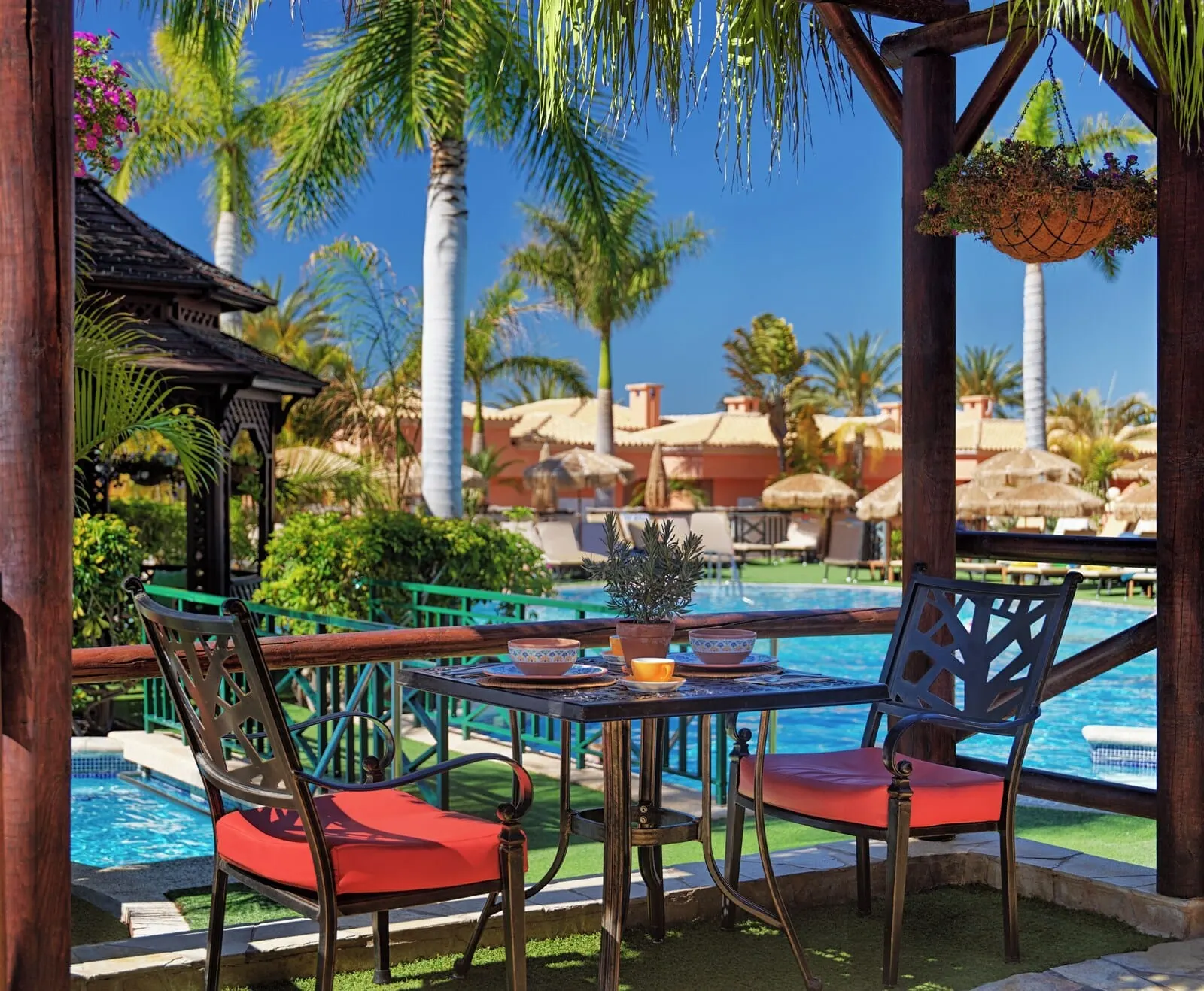 Green Garden Eco Resort & Villas: A poolside area with a table and chairs, a hanging planter