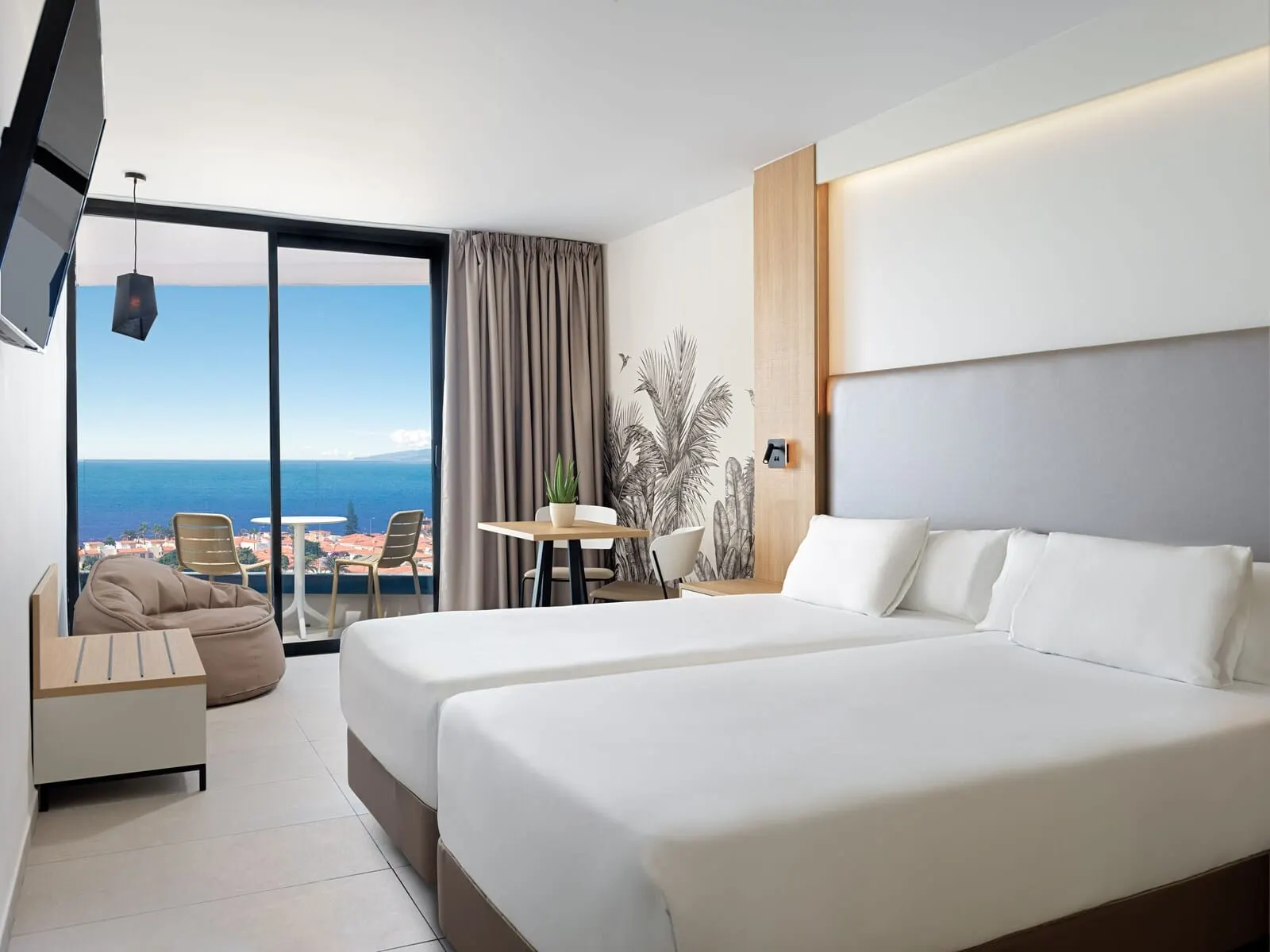 MYND Adeje: A hotel room with a large bed, a desk, a chair, a sofa, and a view of the sea