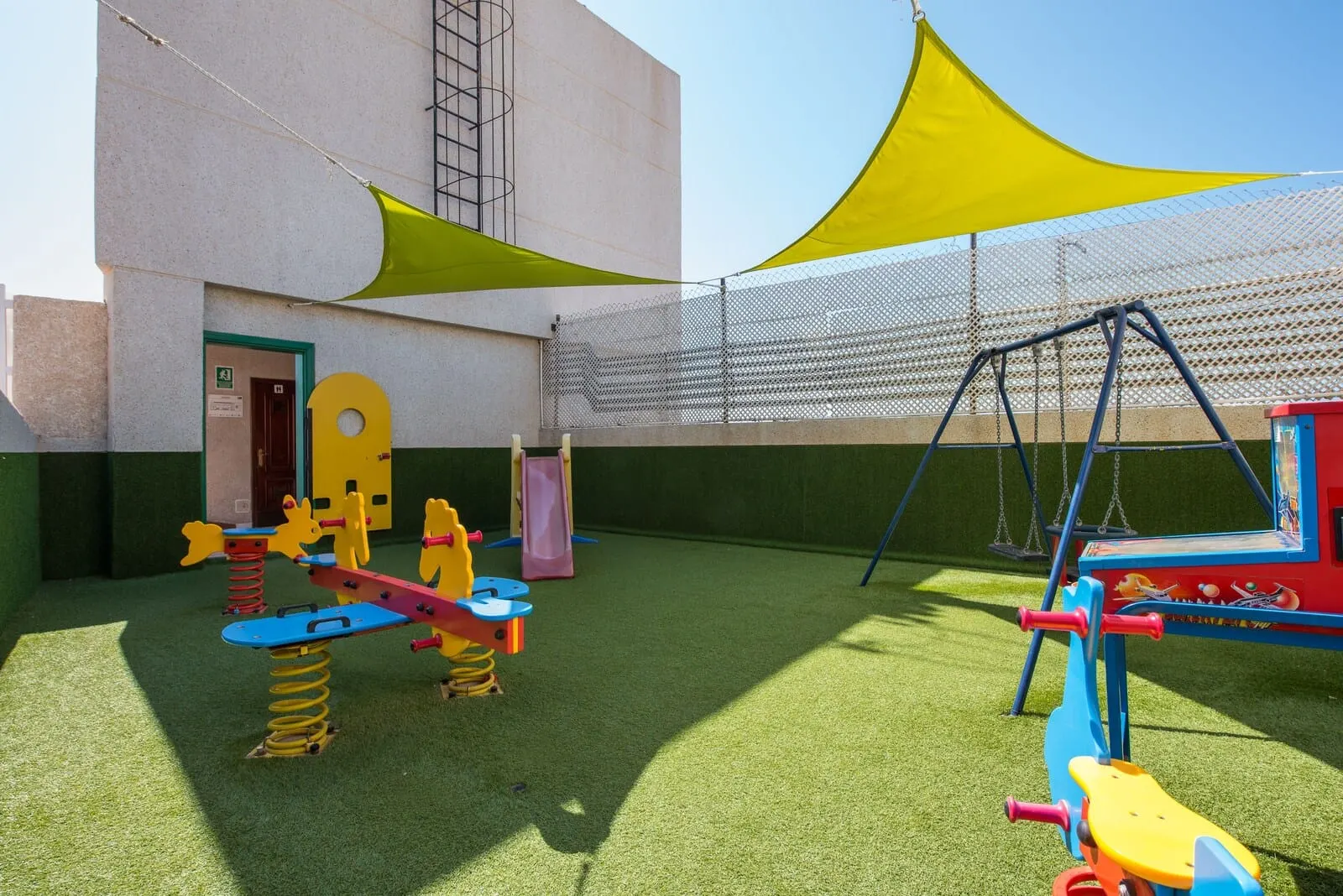 Vigilia Park: A playground with various play equipment, a building with a door