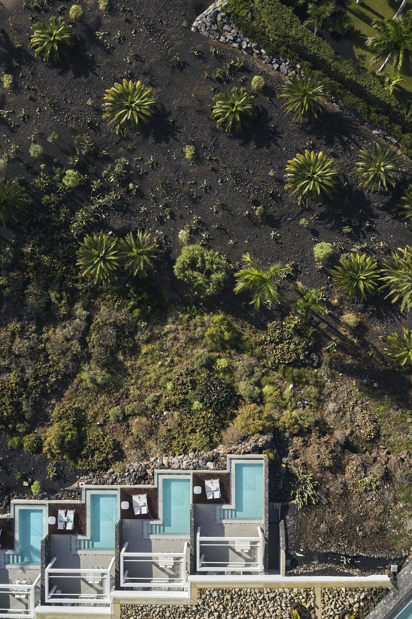 Royal Hideaway Corales Suites: A resort with multiple swimming pools, a rocky hillside, and various tropical plants