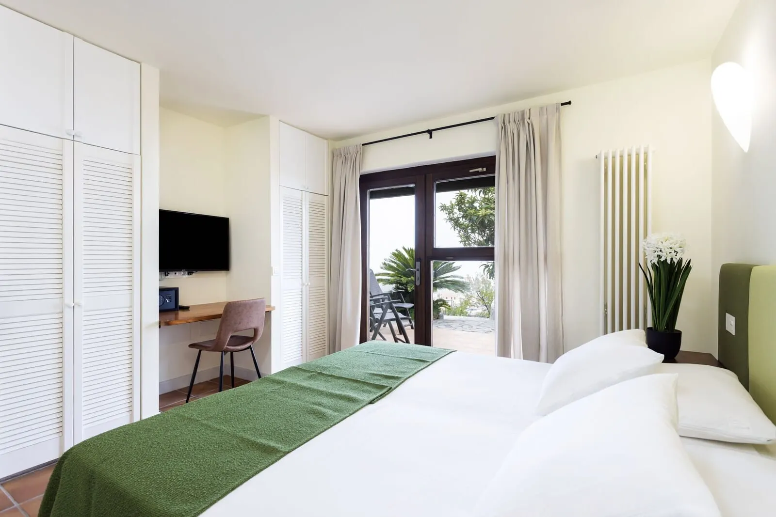 Hotel Alta Montaña: A hotel room with a bed, a desk, a chair, a TV, and a view of the outdoors