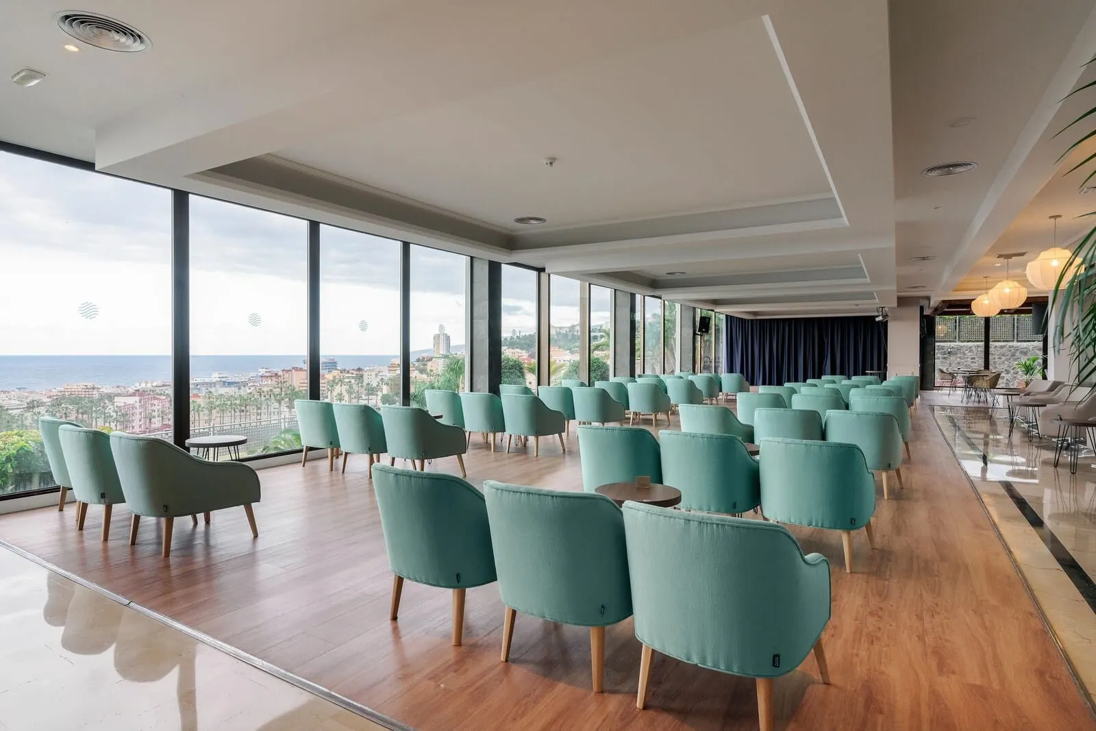 AluaSoul Orotava Valley: A spacious room with rows of teal chairs and wooden flooring