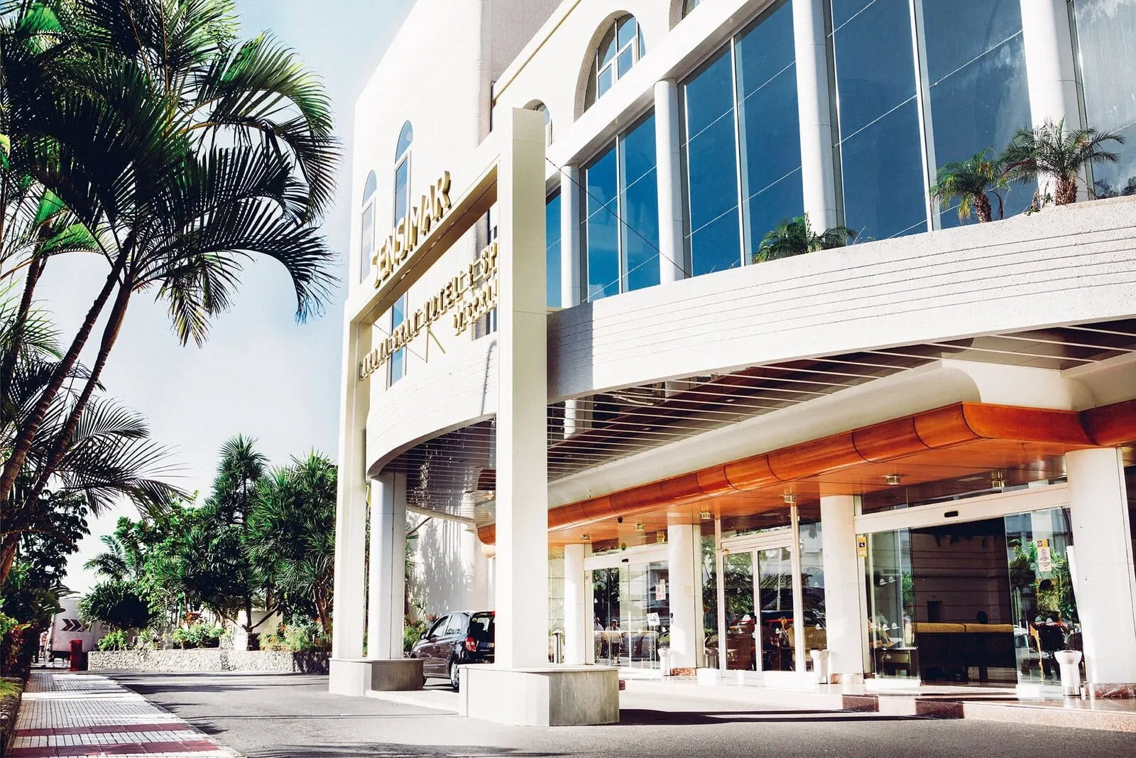 Arona Gran Hotel: A modern hotel with a prominent entrance, large windows, and a covered outdoor area