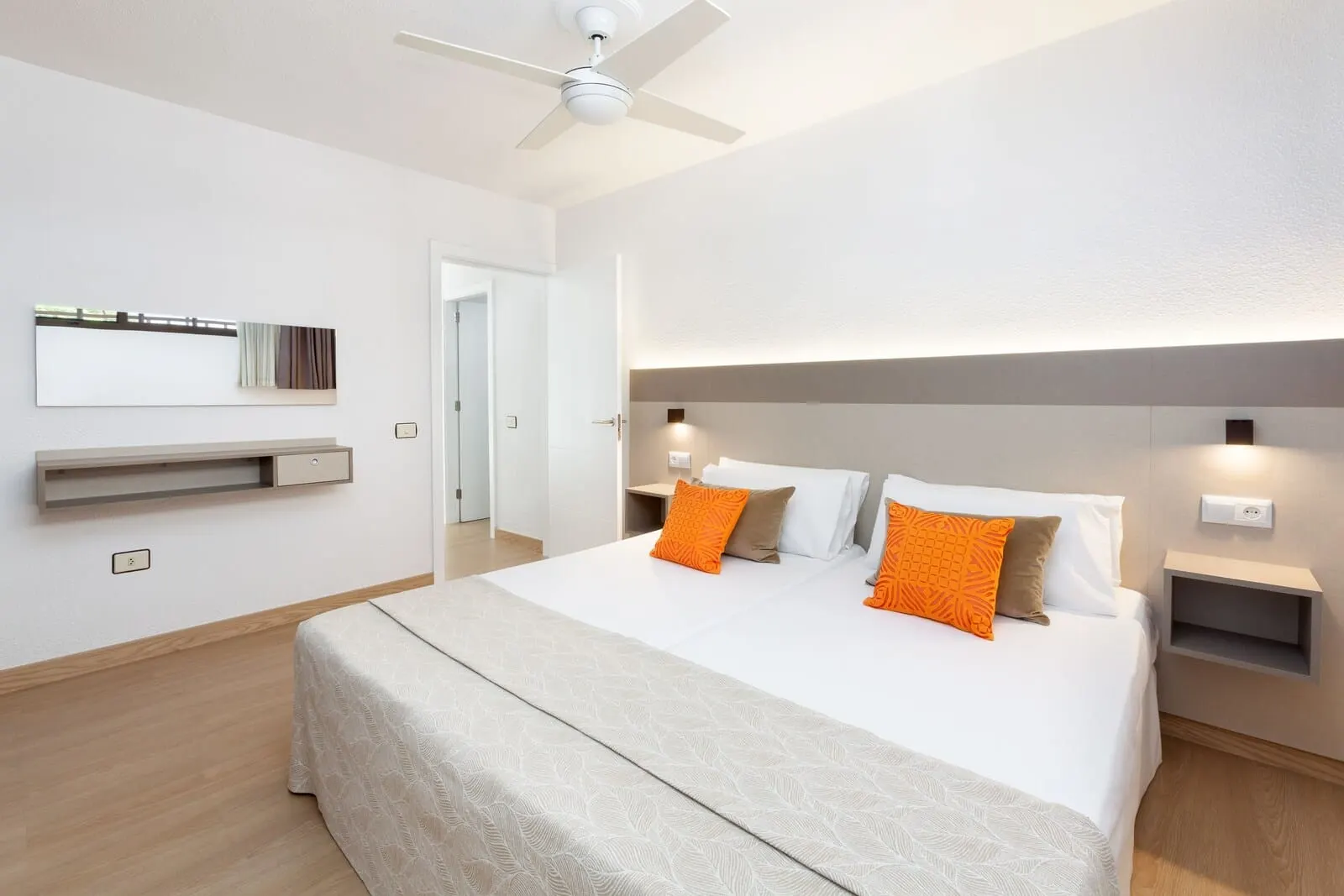 Apartamentos Aguamar: A modern hotel room with a large bed, a ceiling fan, a bedside table