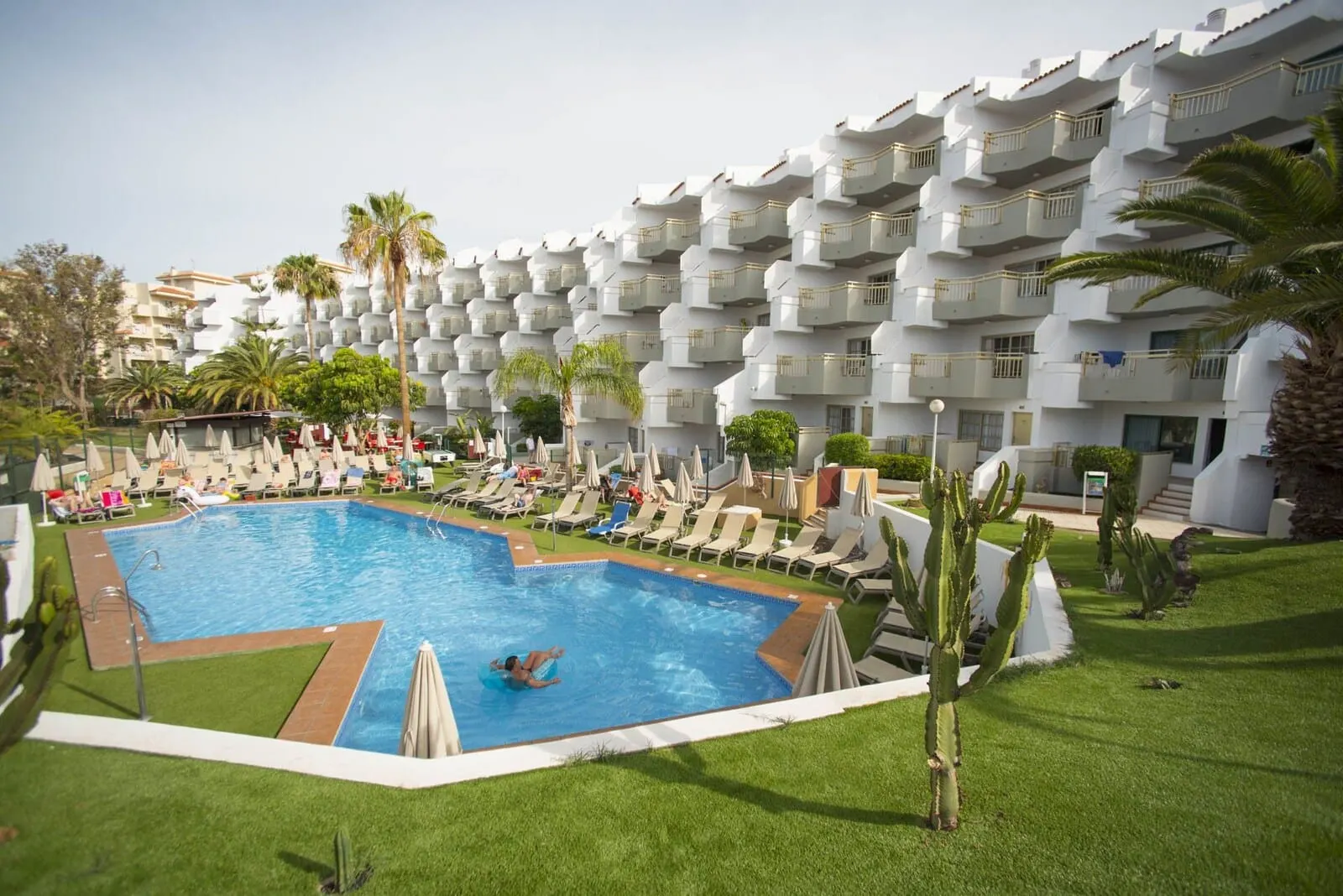 Playaolid Suites & Apartments: A swimming pool surrounded by lounge chairs and umbrellas