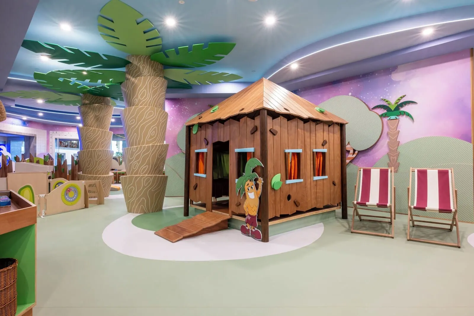 GF Gran Costa Adeje: A children's play area with a wooden playhouse, climbing structures