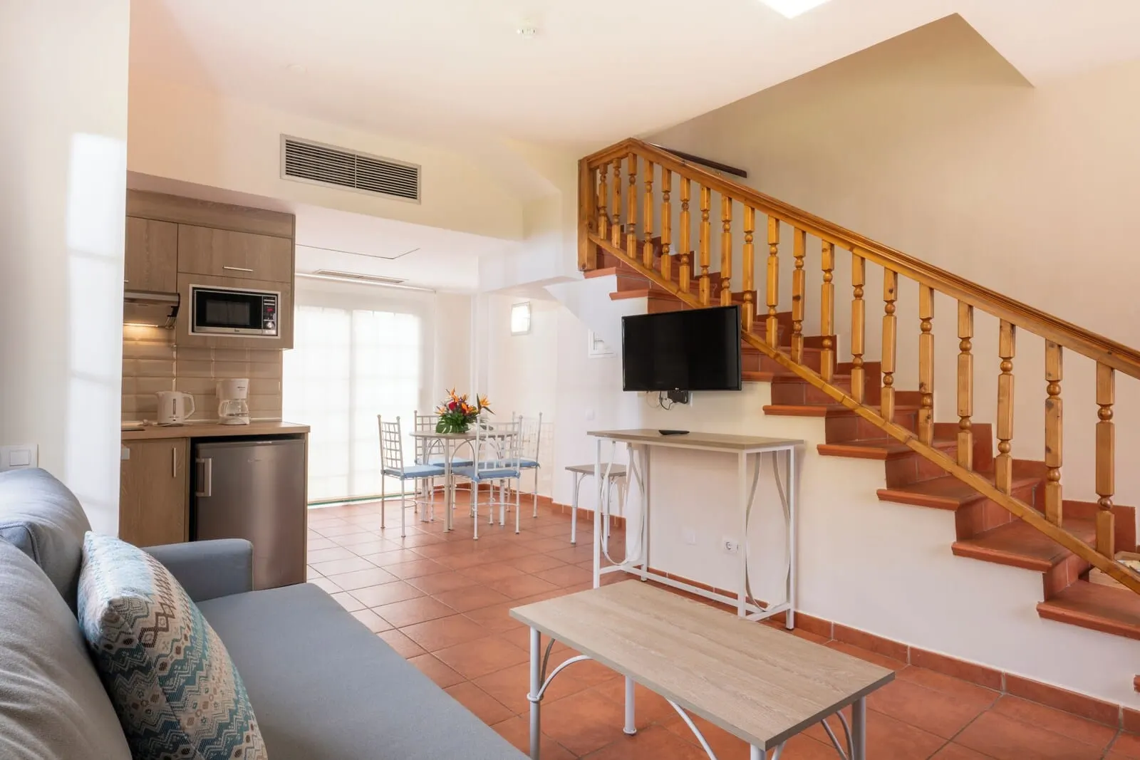GF Isabel: A modern living room with a sofa, a coffee table, and a TV mounted on the wall