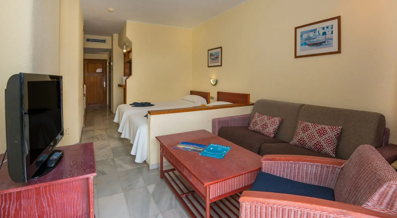 HOVIMA Atlantis: A hotel room with a TV, a sofa, a bed, and a desk