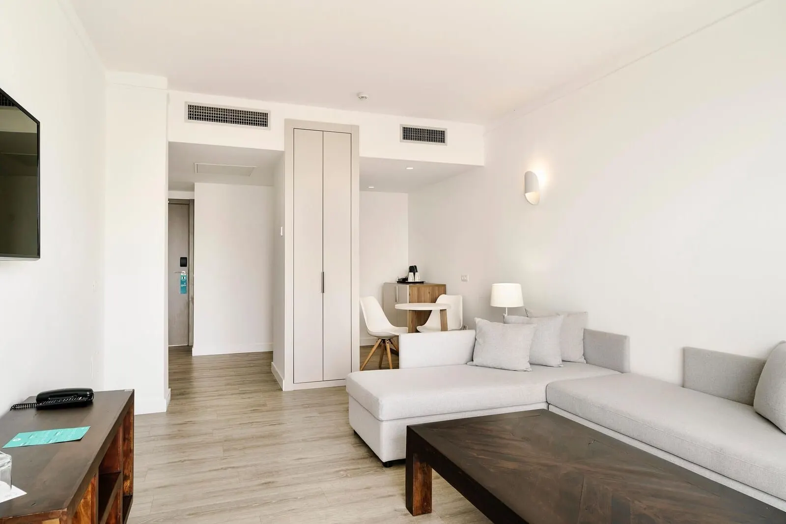 Alua Atlántico Golf Resort: A modern living room with a sectional sofa, a wooden coffee table