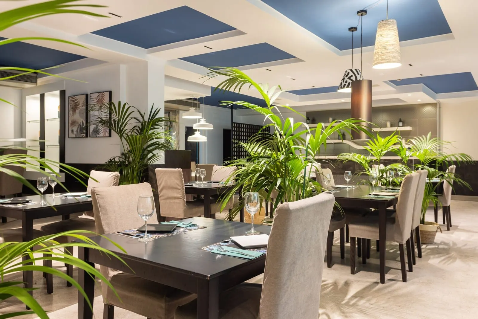 Hotel Colón Rambla: A modern dining area with multiple tables, chairs, and hanging pendant lights