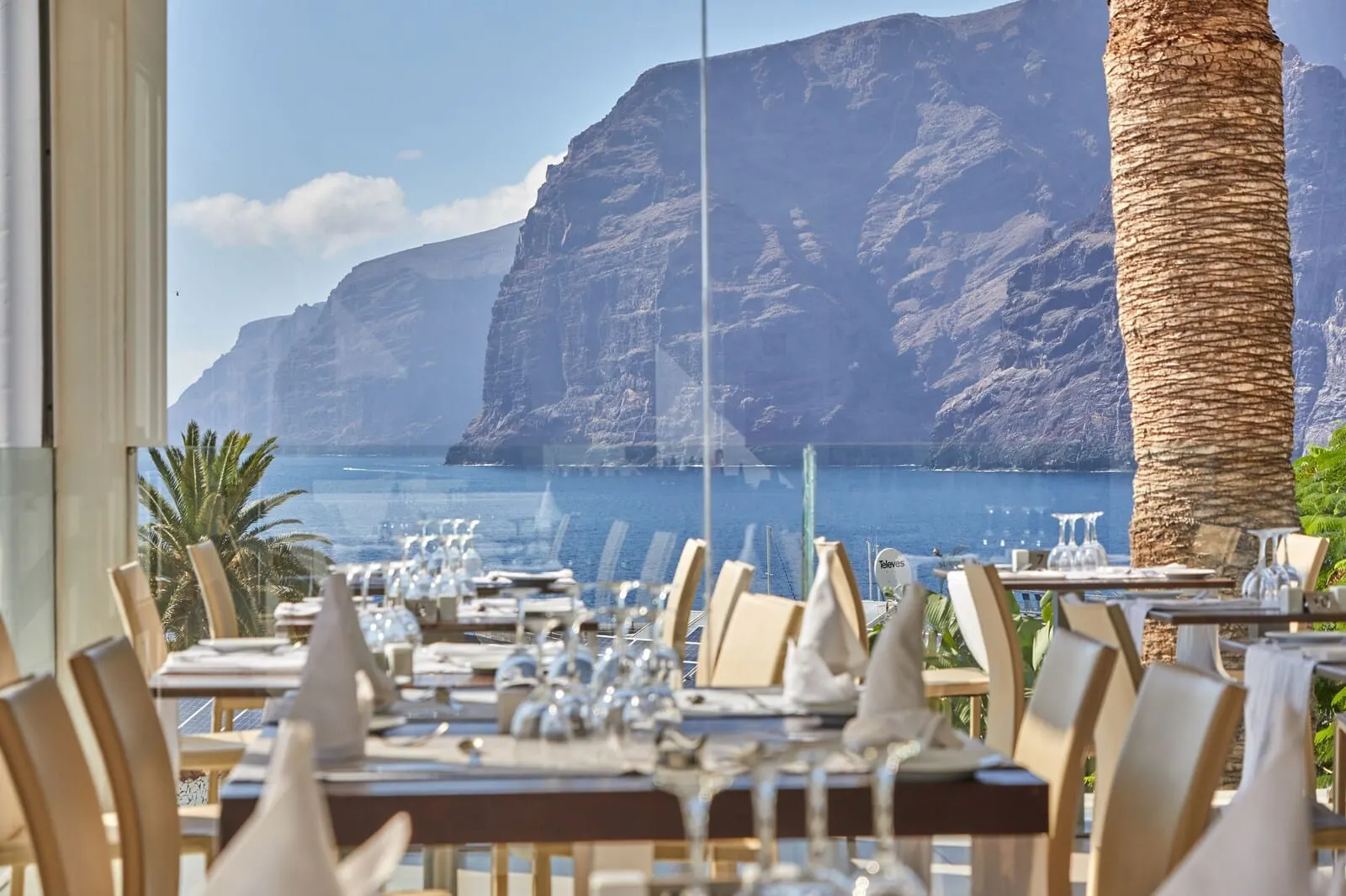 TUI Blue Los Gigantes: A restaurant with tables set for dining, overlooking a coastal cliff and the sea