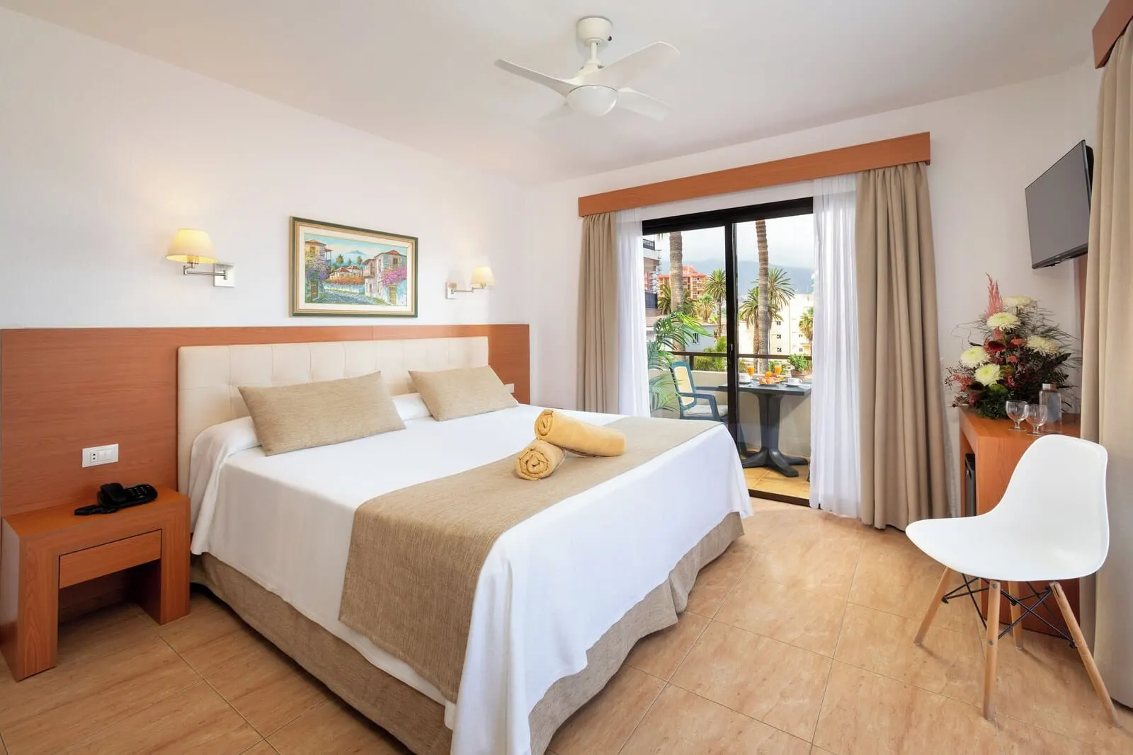 Hotel Don Manolito: A hotel room with a large bed, a bedside table, a chair, a ceiling fan, a TV