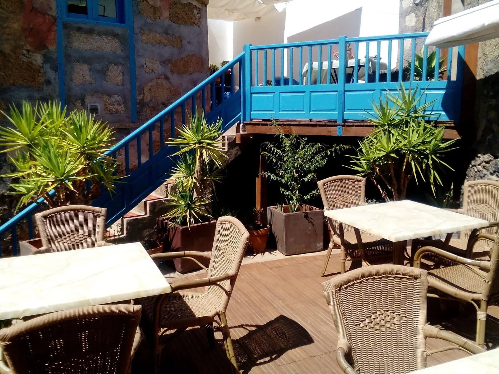 Hotel Cuatro Esquinas: An outdoor patio area with wicker furniture, potted plants
