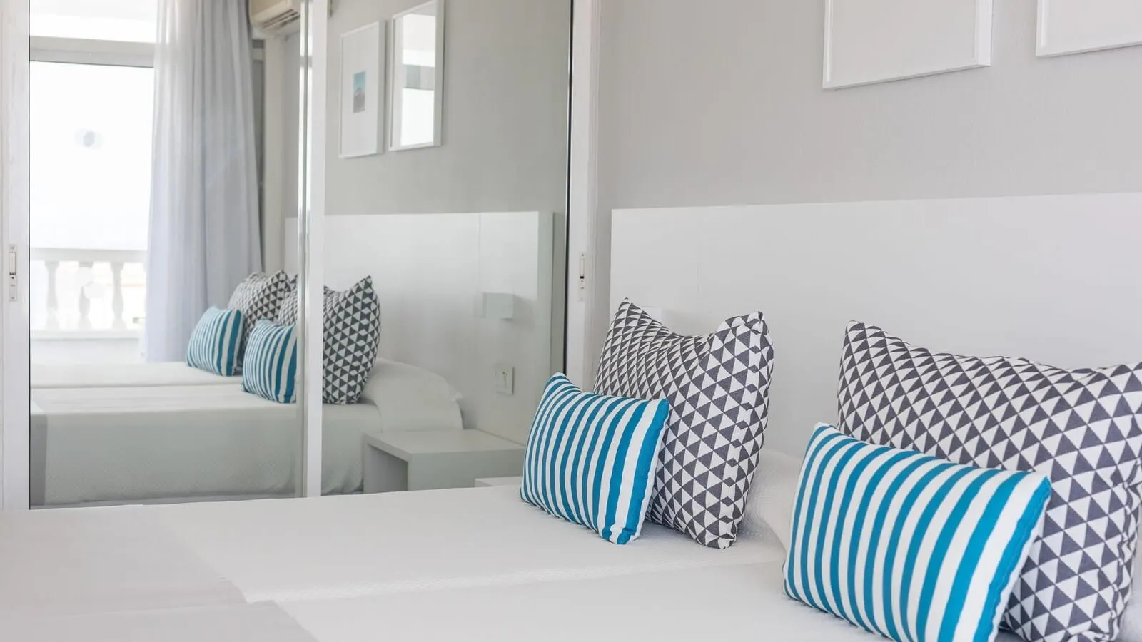 BlueSea Lagos de César: A modern hotel room with a large bed, a bedside table, and a mirror